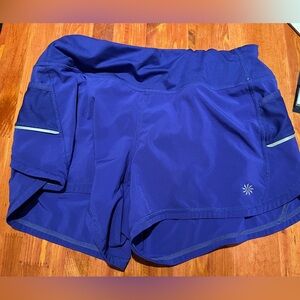 Athleta purple running shorts with pockets and reflectors.